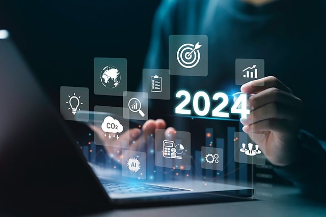 *Current Economic State of the US*—A person working on a laptop surrounded by digital icons representing finance, technology, AI, and global markets, with "2024" prominently displayed—symbolizing economic analysis, innovation, and future financial projections.