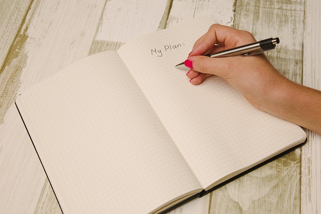 a hand writing on a notebook