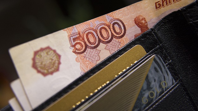A 5000 Russian ruble note and two credit cards in a black wallet.