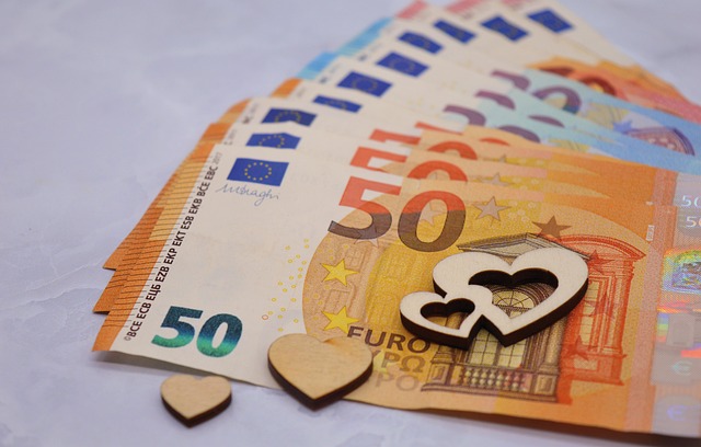 Euro banknotes with wooden heart shapes, symbolizing financial security and the best assets for inflation.