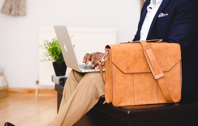 Types of Financing—A person in business attire working on a laptop with a leather bag on their lap, symbolizing professional decision-making, modern finance methods, and diverse funding options.