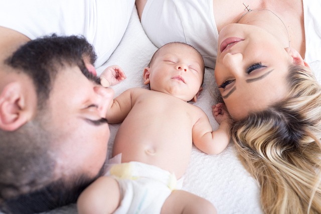*Family Financial Planning*—A family lying together on a bed, with a baby at the center, symbolizing financial security, budgeting for a household, and planning for a stable future.