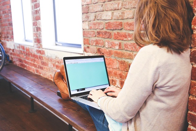 Person working on a laptop preparing a contact us finance blog page
